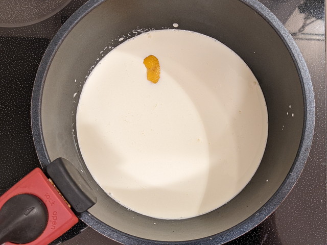 鍋に生クリーム・牛乳・レモンの皮を入れて、泡立て器で混ぜる